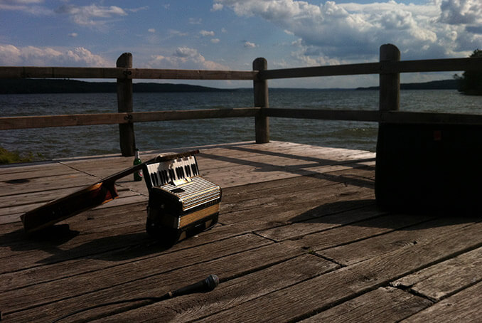 Gitarre und Akkordeon auf einem Steg am See